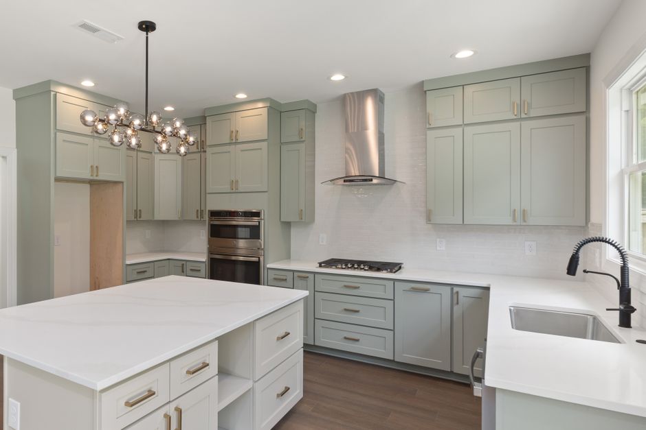 Bright modern kitchen featuring custom cabinets and stylish lighting, perfect for contemporary homes.