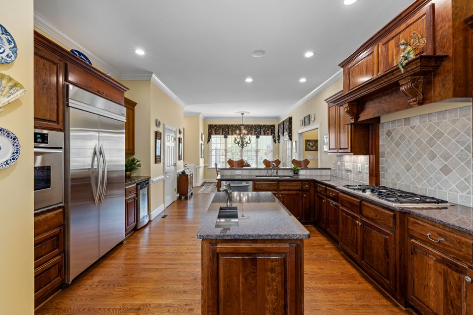 Modern kitchen with wooden cabinets and granite countertops, featuring stainless steel appliances.